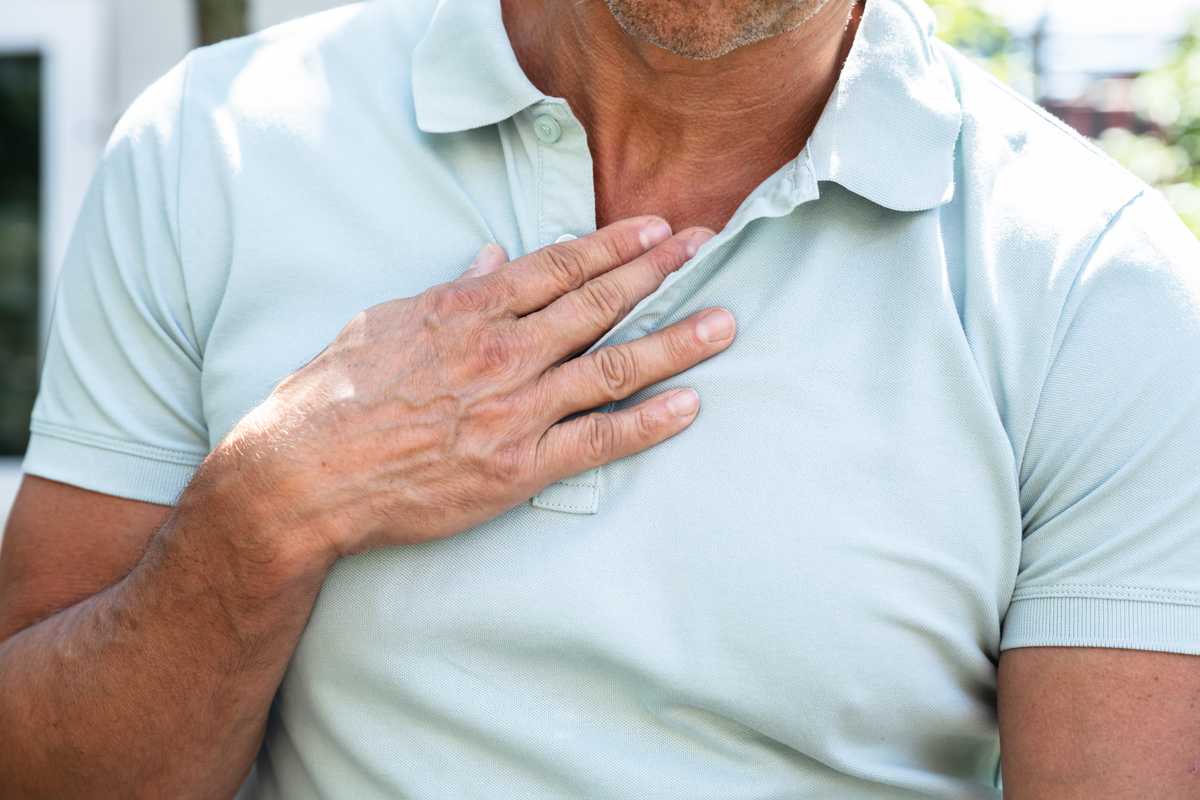 Mężczyzna trzymający się z bólu za pierś